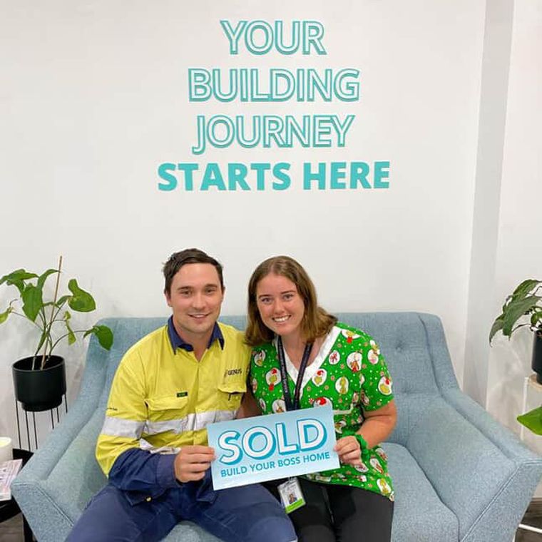 House of Boss clients with the Sold sign on their new block.