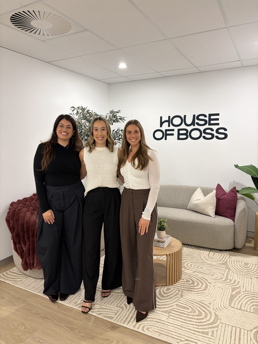 The House of Boss team at their Perth office, in front of the House of Boss sign.